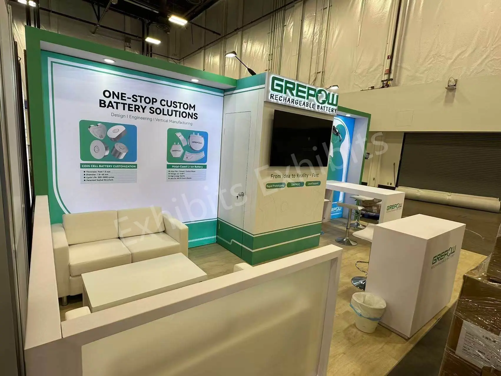 GREPOW exhibit seating area with sofa, low table and battery-solution backwall